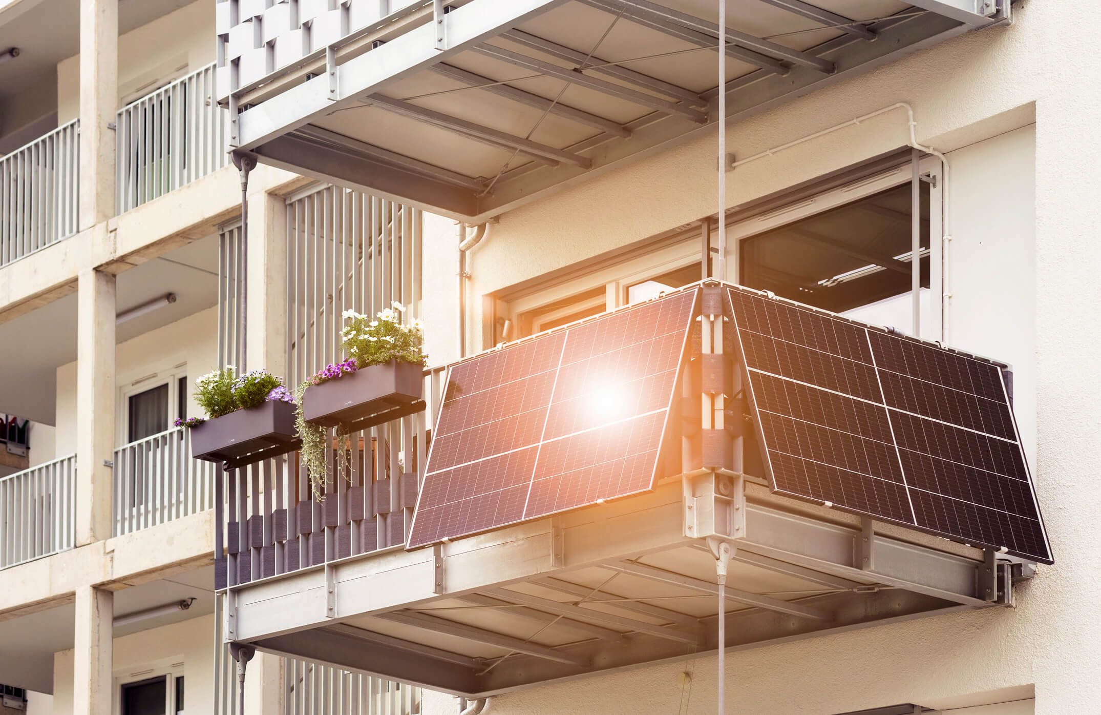 Balkon mit Balkonkraftwerk, dessen Module das Sonnenlicht reflektieren