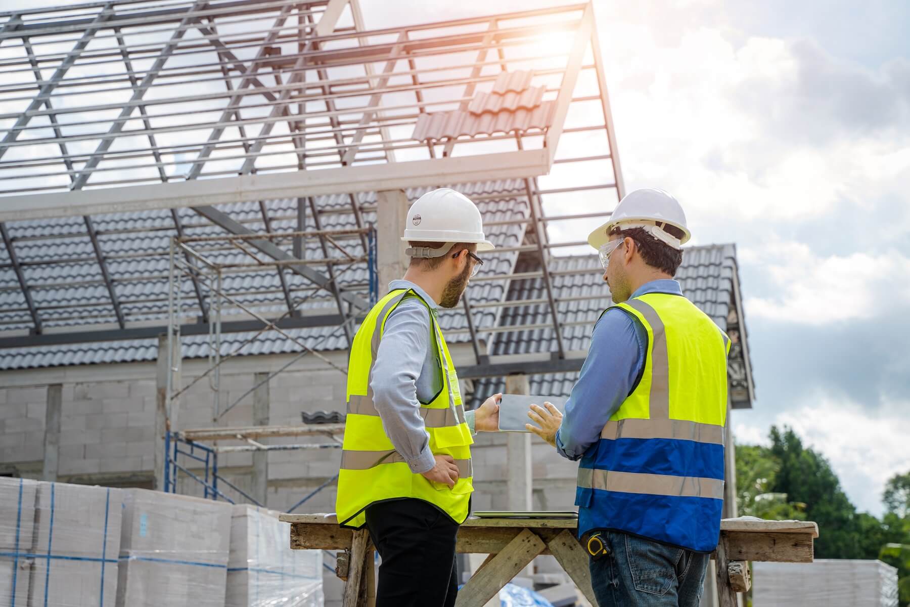 Ingenieure analysieren einen Bauplan auf der Baustelle eines neuen Hauses