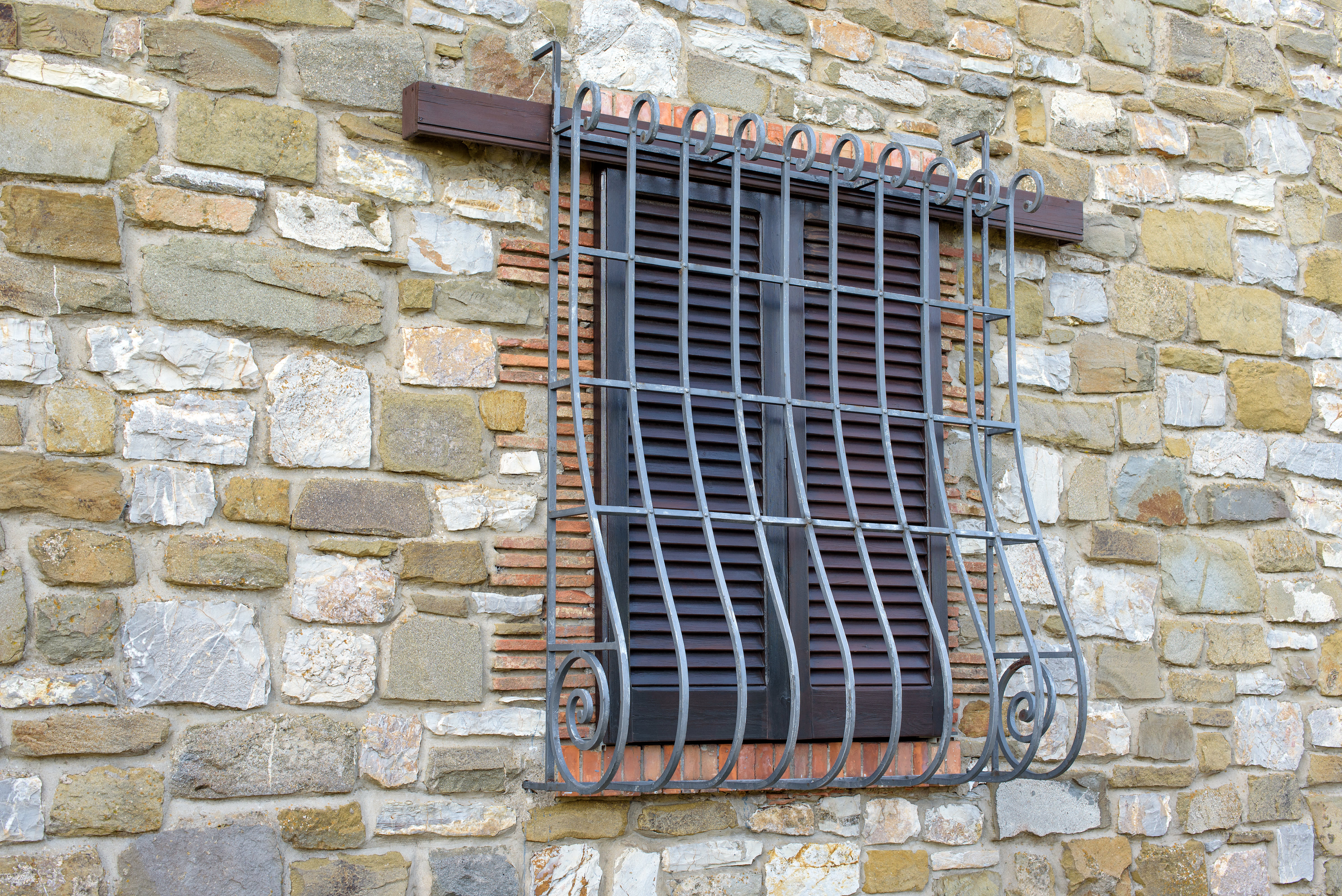 Fenster mit Fenstergitter mit Bauch in einer Steinmauer