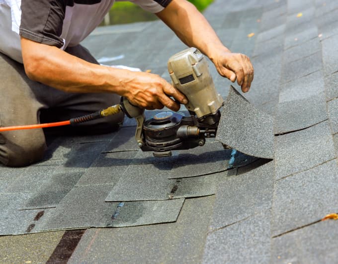 Bild von zufriedenen Hauseigentümern und Handwerkern, die sich die Hände schütteln.