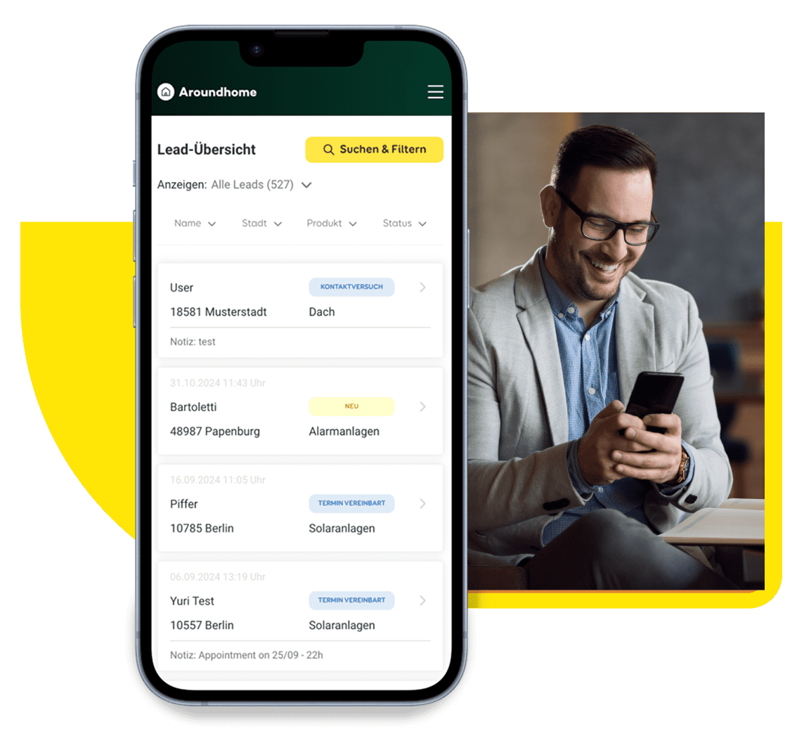 Im Vordergrund steht ein Mobiltelefon mit dem Partner Cockpit von Aroundhome, im Hintergrund bedient eine freundliche Handwerkerin das Cockpit auf dem Handy.
