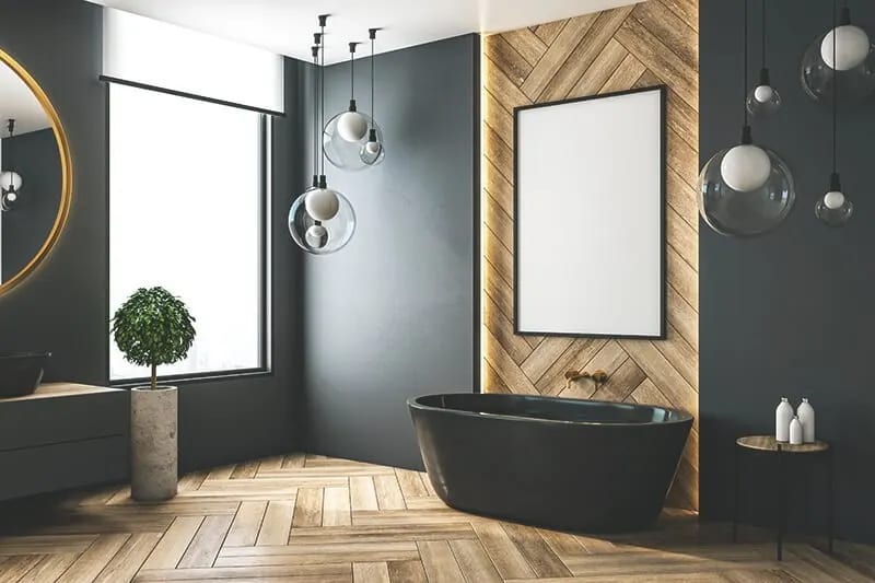 Zu sehen ist ein modernes Badezimmer mit hellem Holzboden, dunkler Wand und dunklen Amarturen und Badewanne.