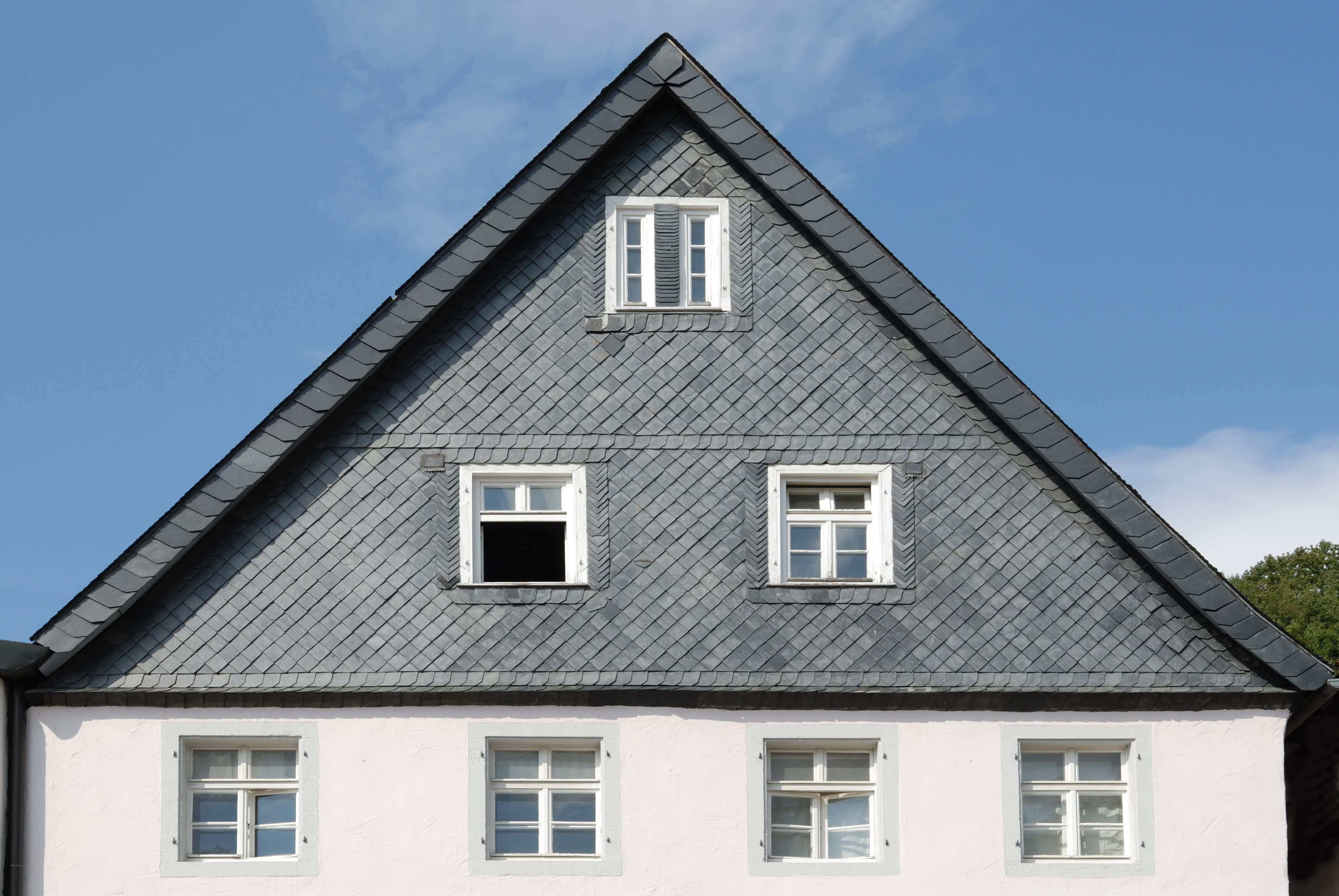 Einfamilienhaus mit Schieferfassade im oberen Stockwerk