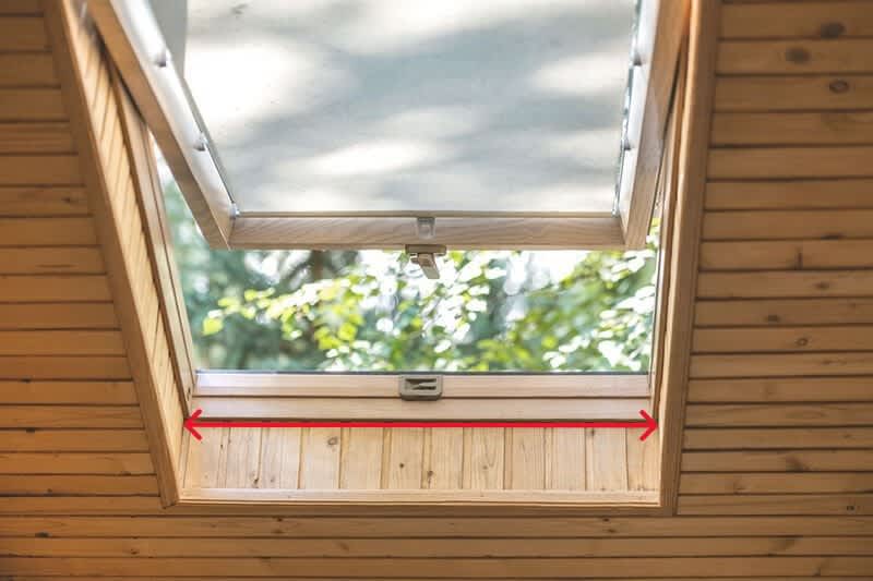 Offenes Dachfenster mit Markierung, wo die Fensterbreite gemessen wird.