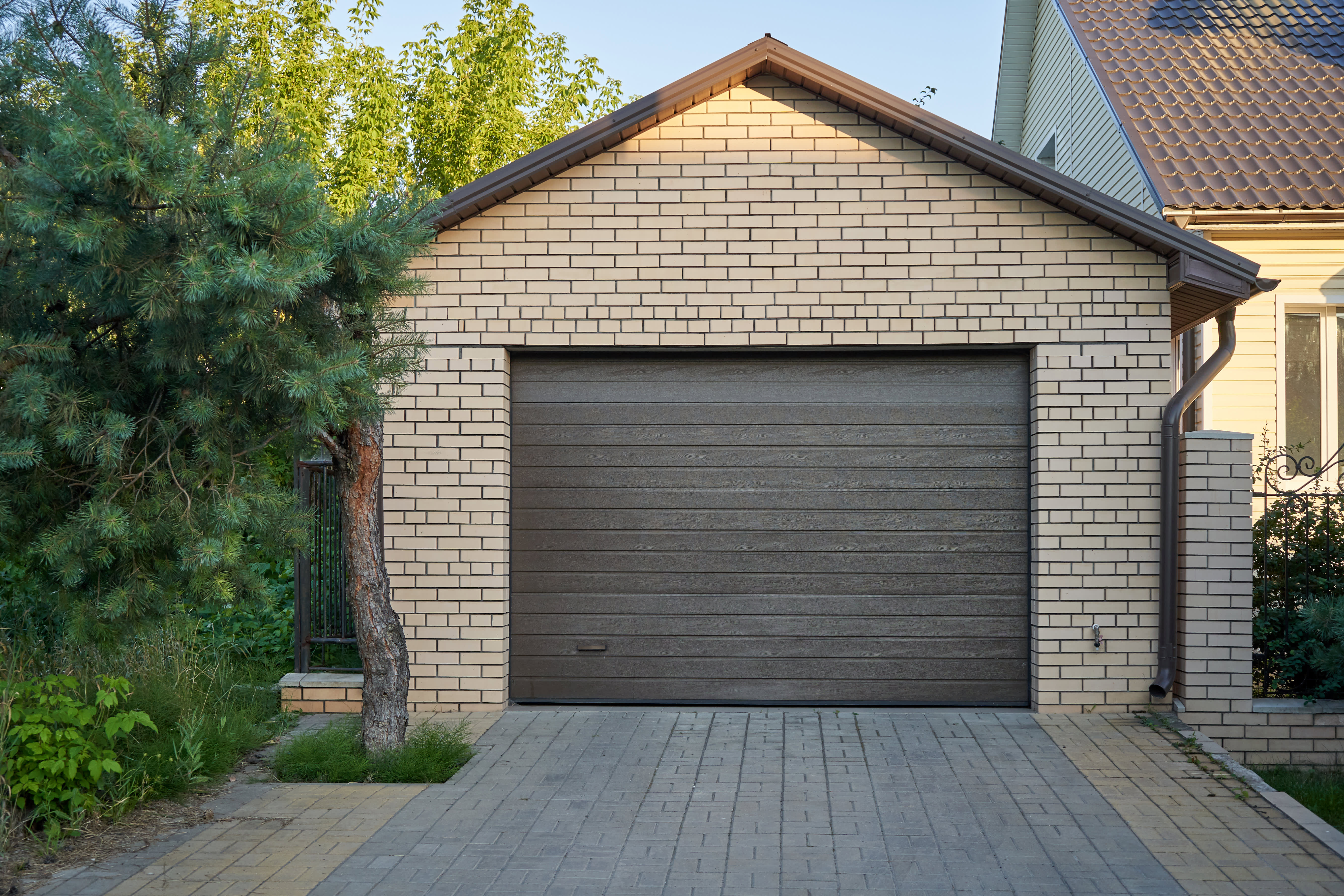 Gemauerte Garage mit Platz für ein Auto neben einem Wohnhaus