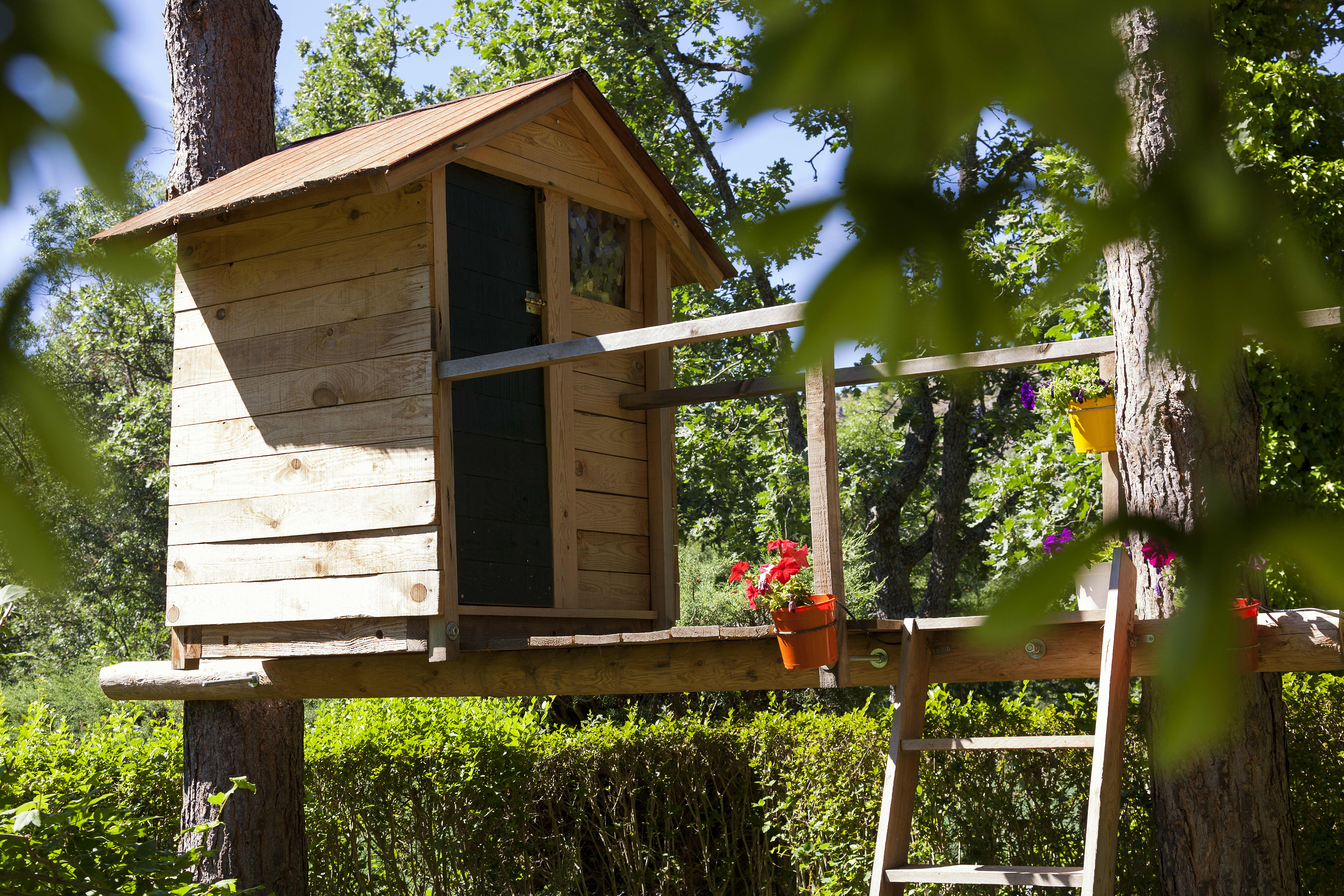 Garten mit einem Baumhaus aus Holz.