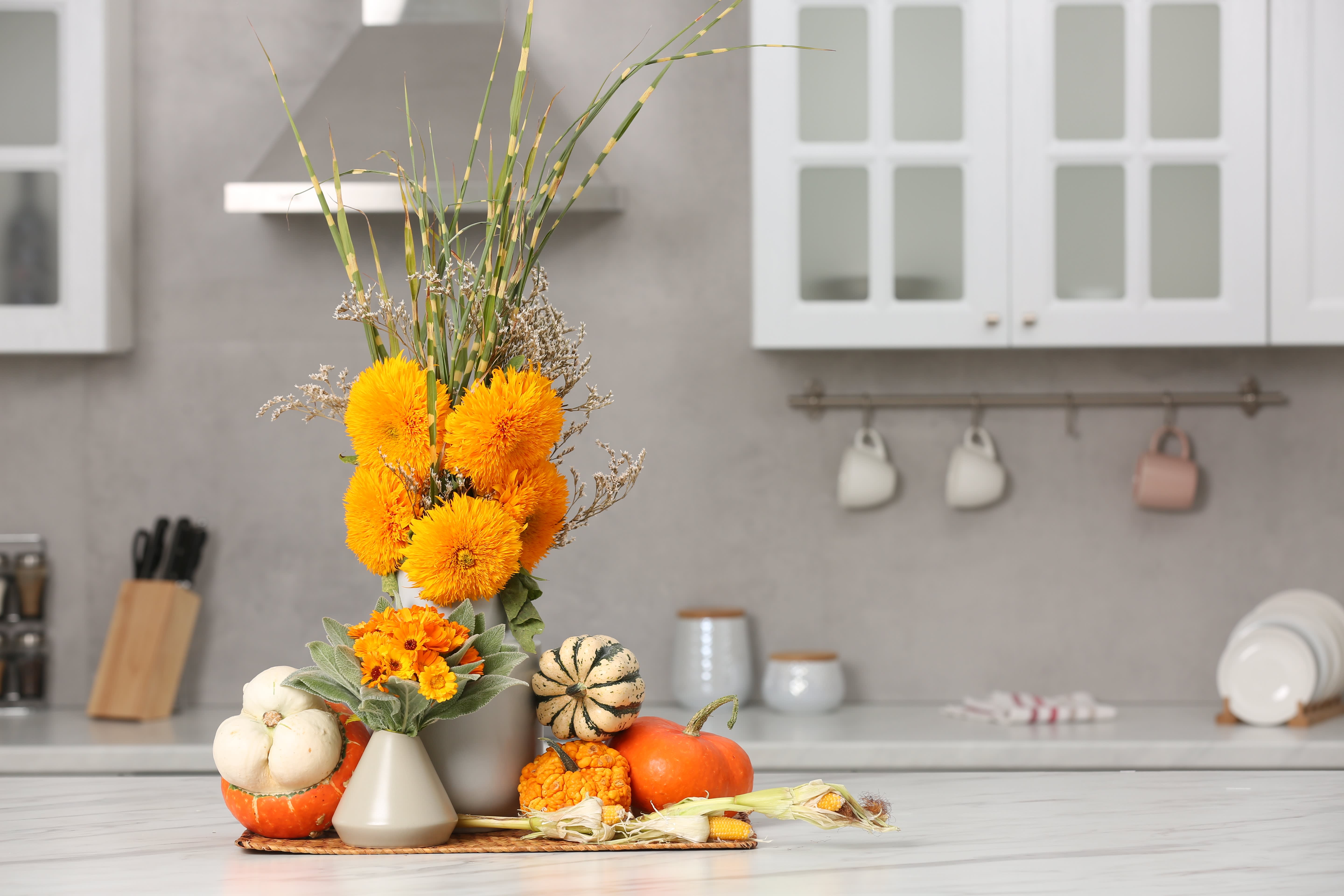 Blumen- und Kürbisarrangement in einer weißen Küche