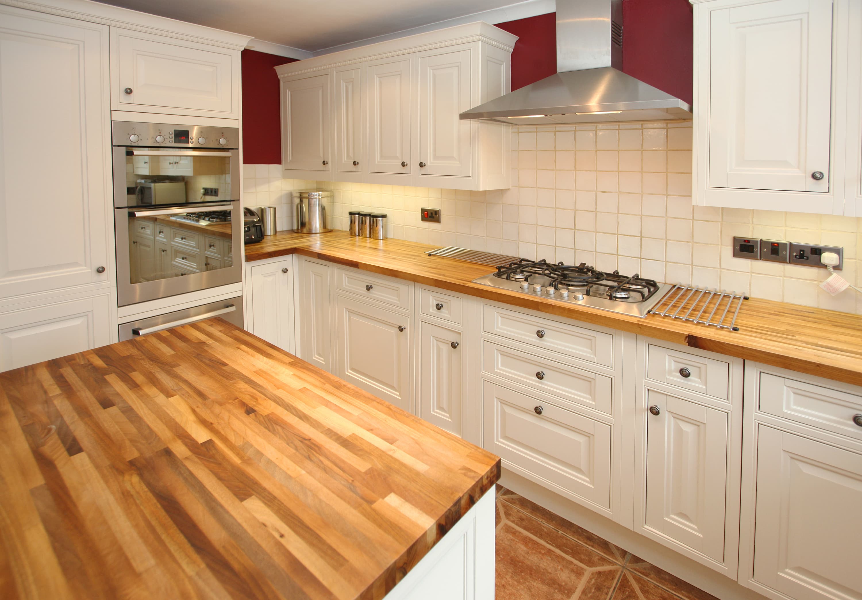 Moderne Landhausküche mit weißen Fronten und Arbeitsplatten aus Holz