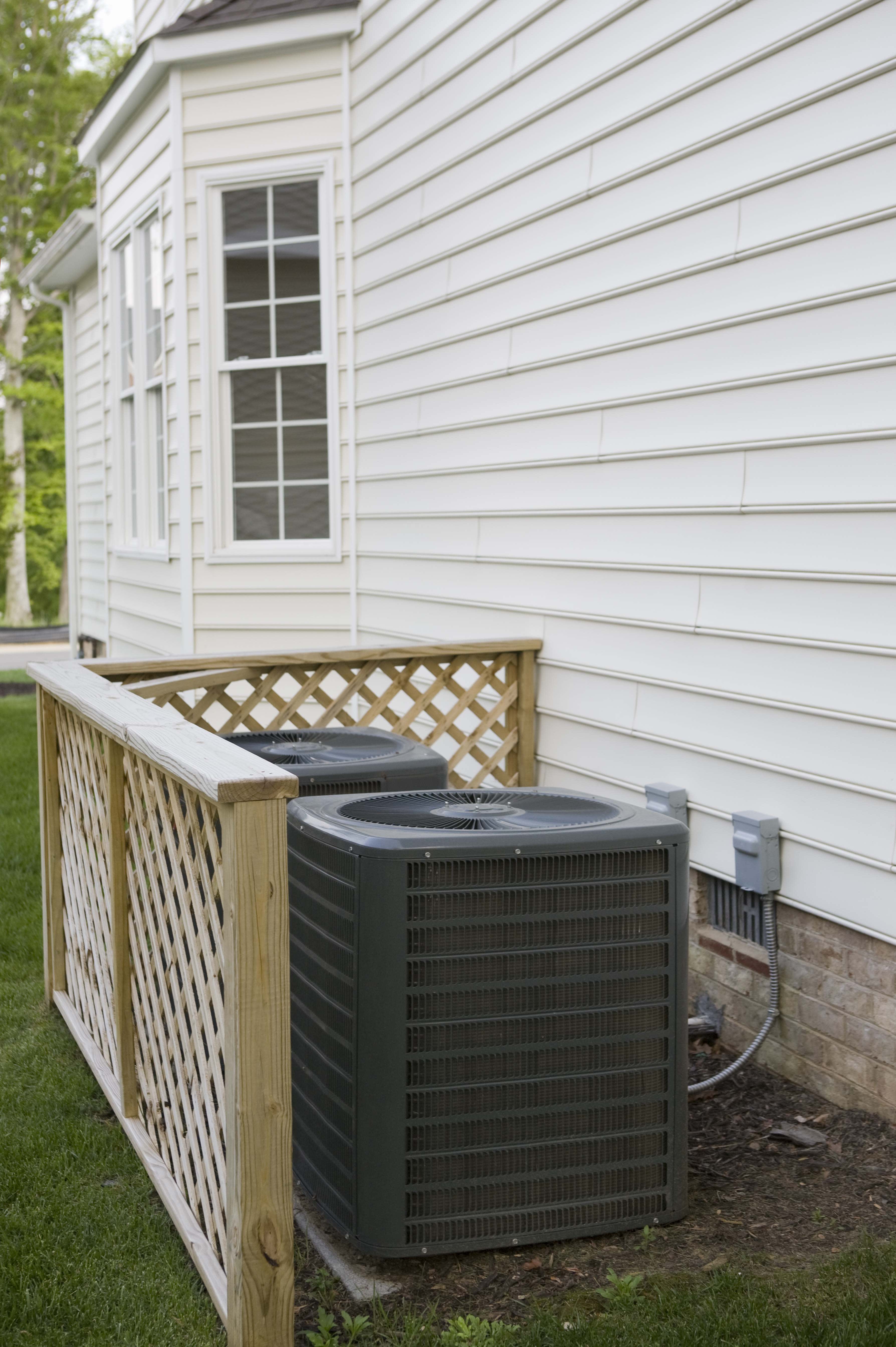 Klimaanlage durch Zaun im Garten verstecken