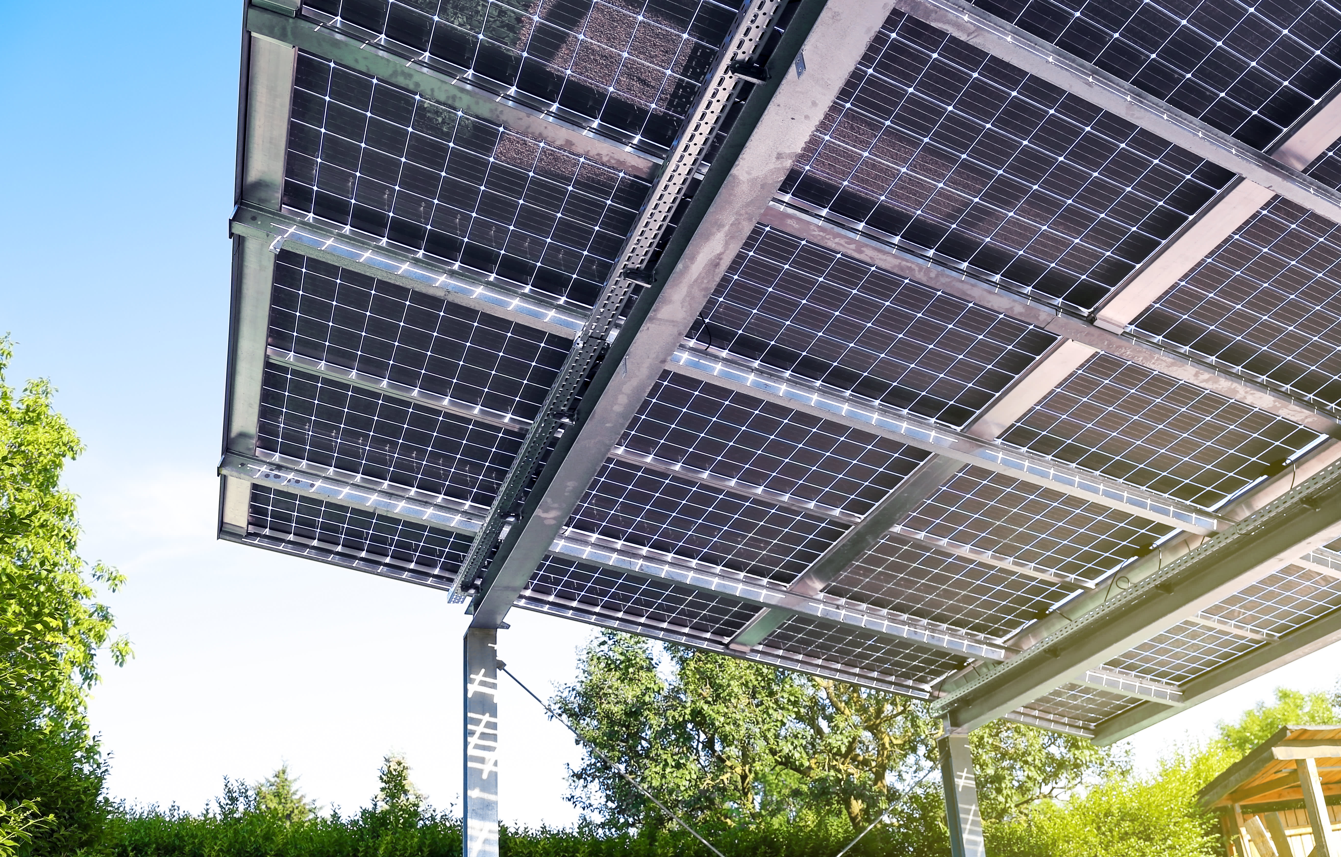 Glas-Glas-Solarmodule bilden die Überdachung einer Terrasse im Garten.