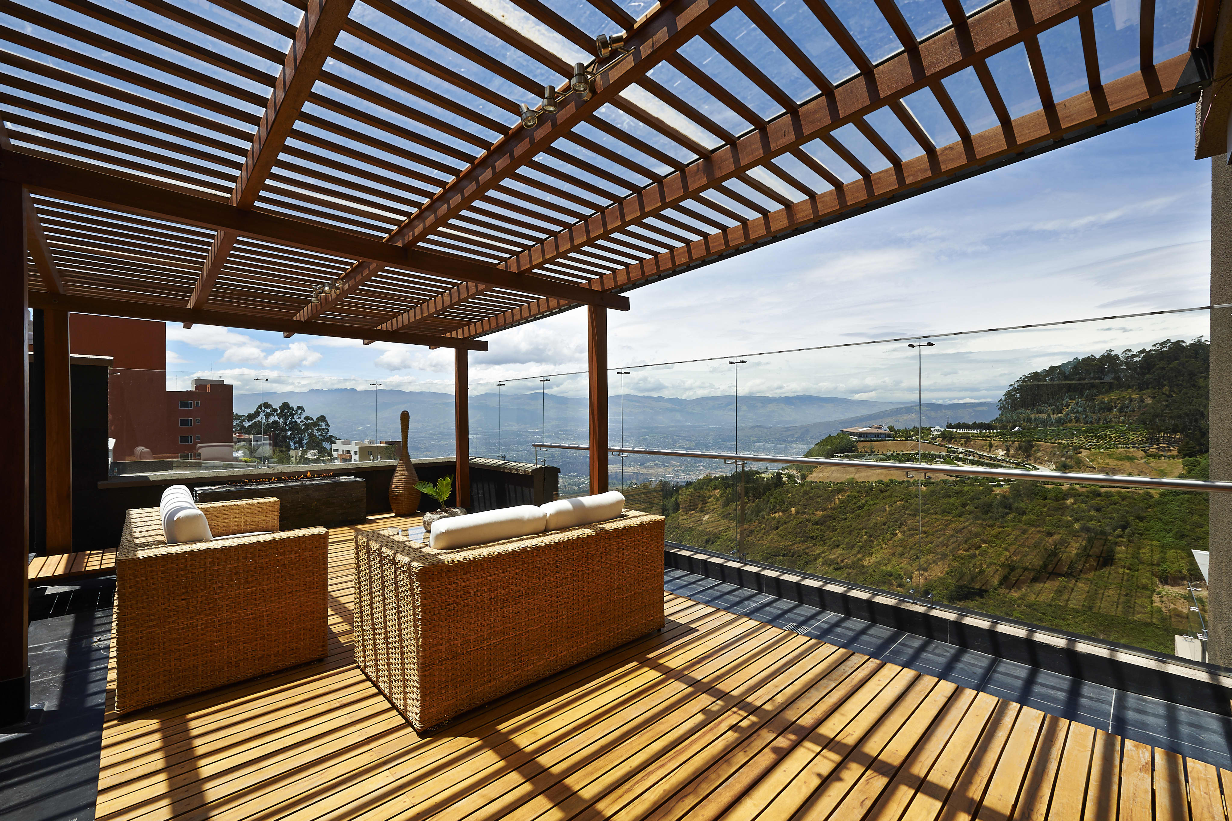Holz-Terrassenüberdachung mit Glasdach und schönem Ausblick von Terrasse.