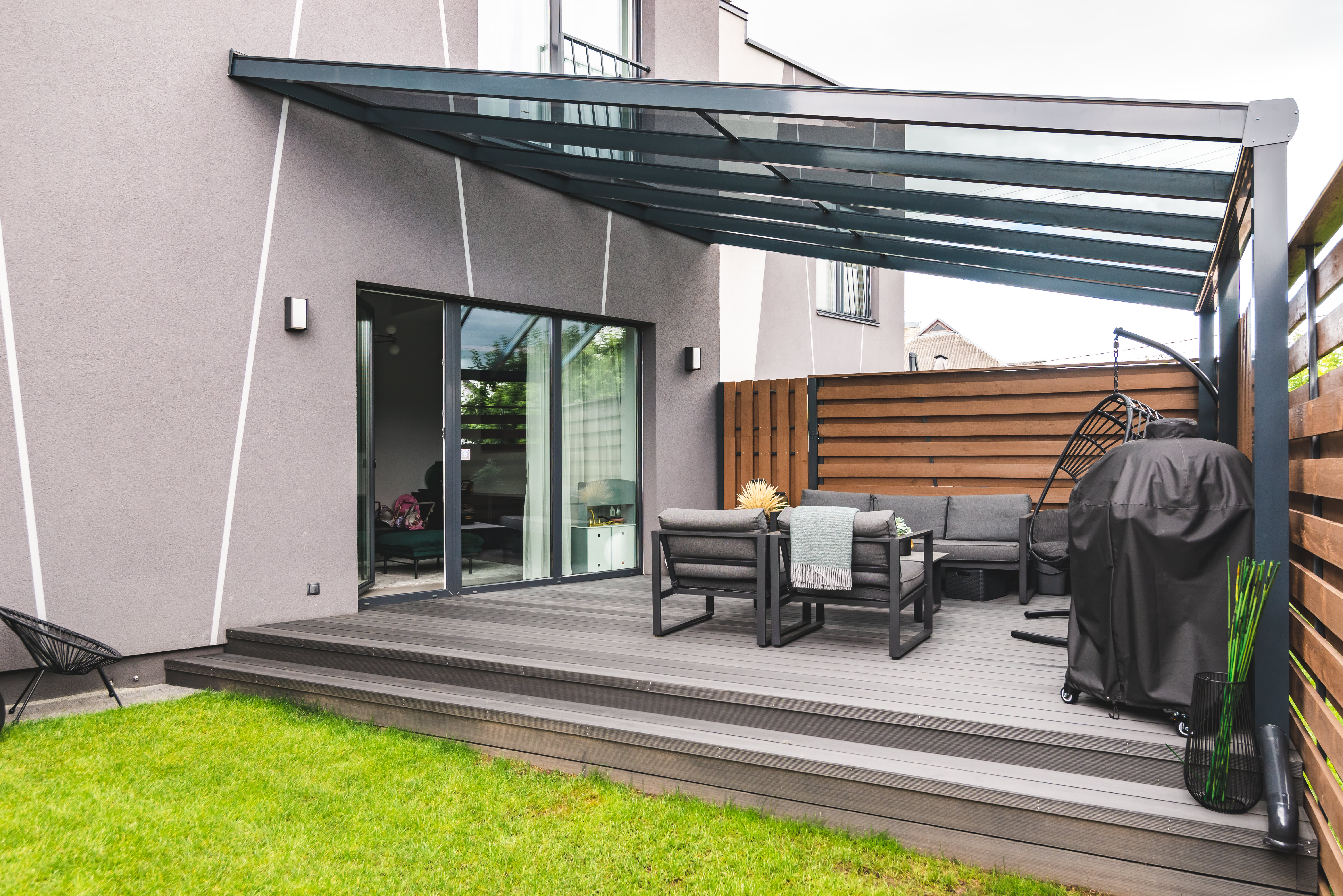 Terrassenüberdachung aus Aluminium mit einer starken Neigung über einer modernen Terrasse