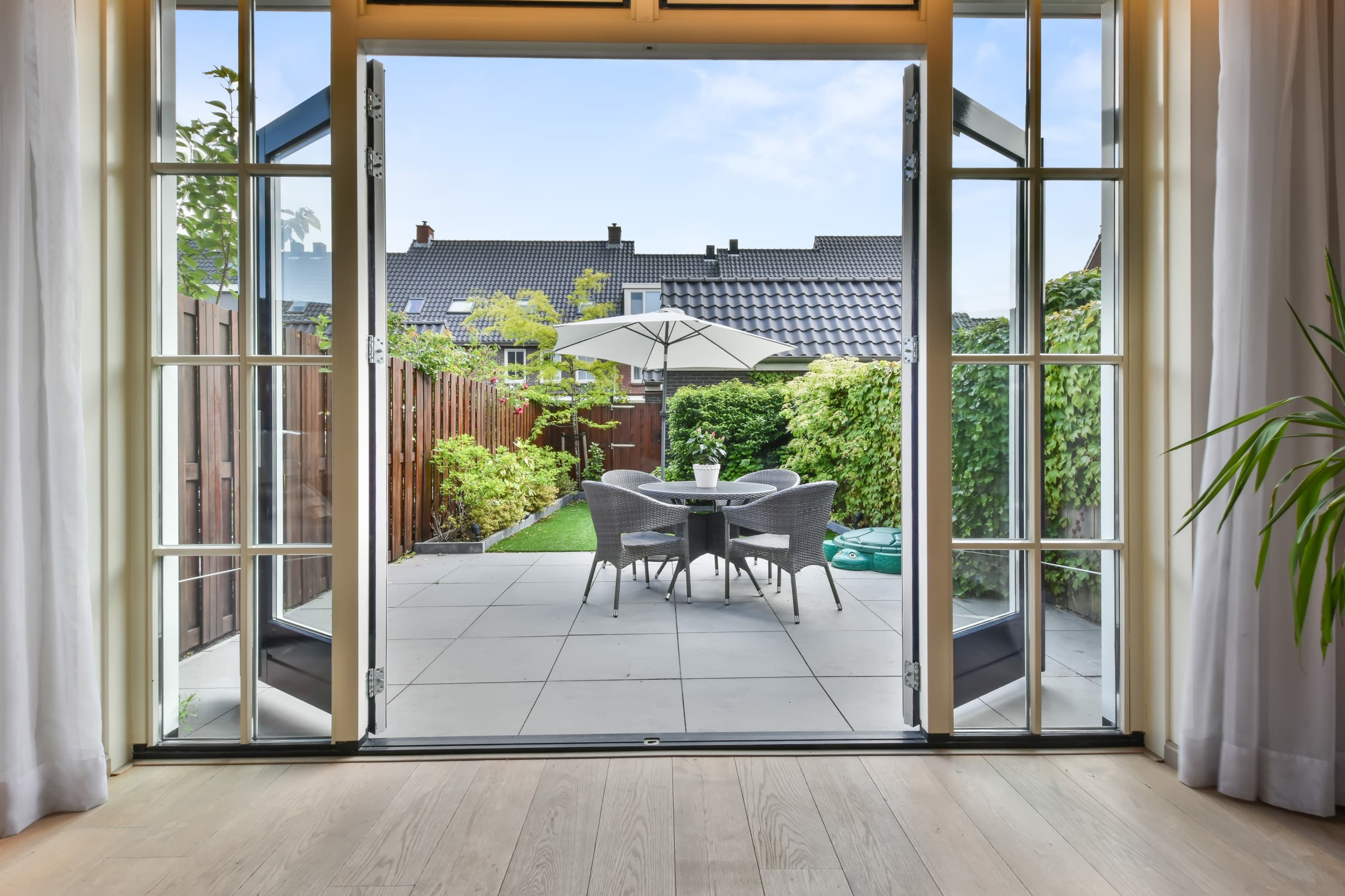 Blick durch eine offene Terrassentür auf die Terrasse