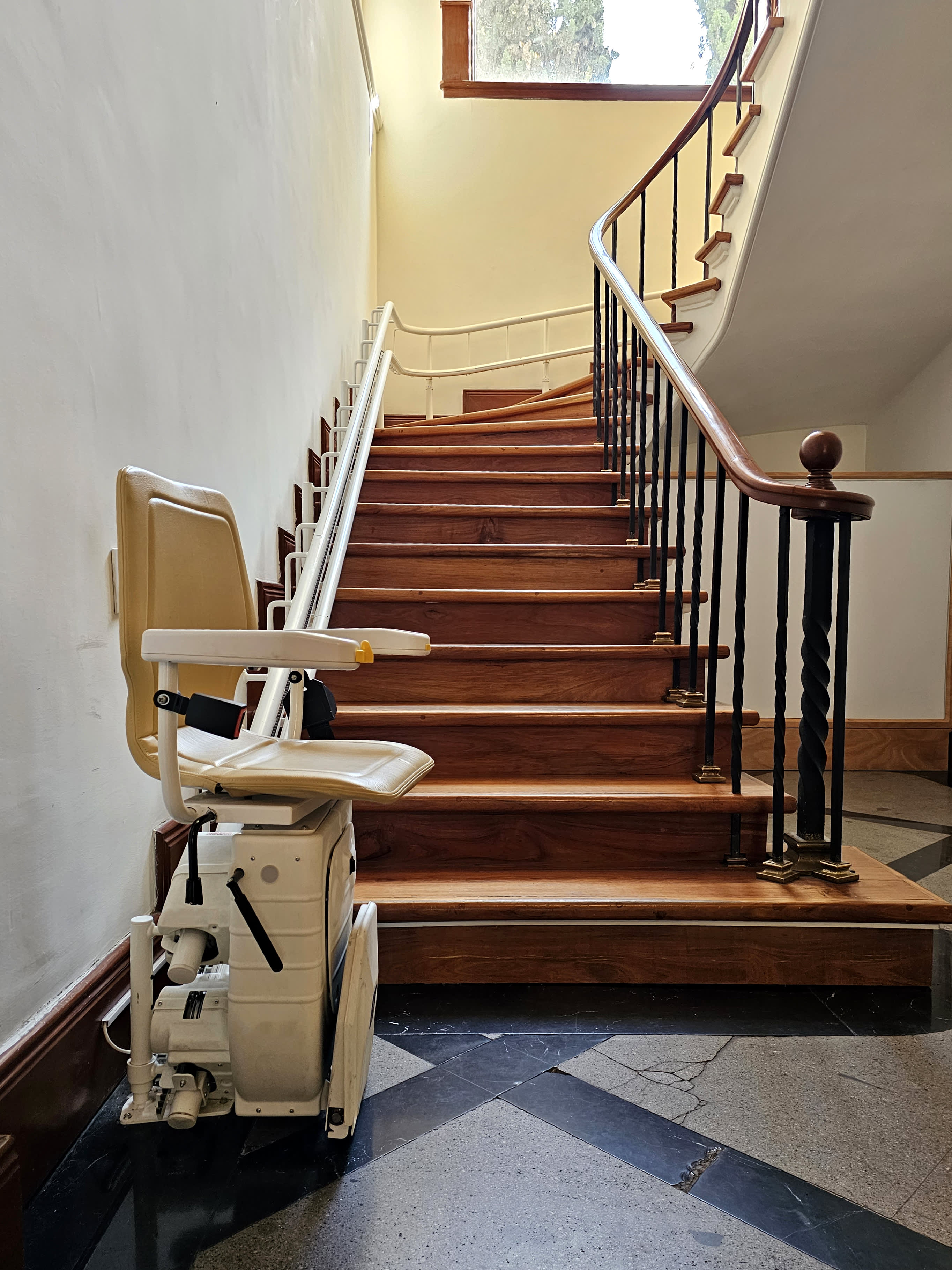 Sitzlift an einer Wendeltreppe eines Mehrfamilienhauses.