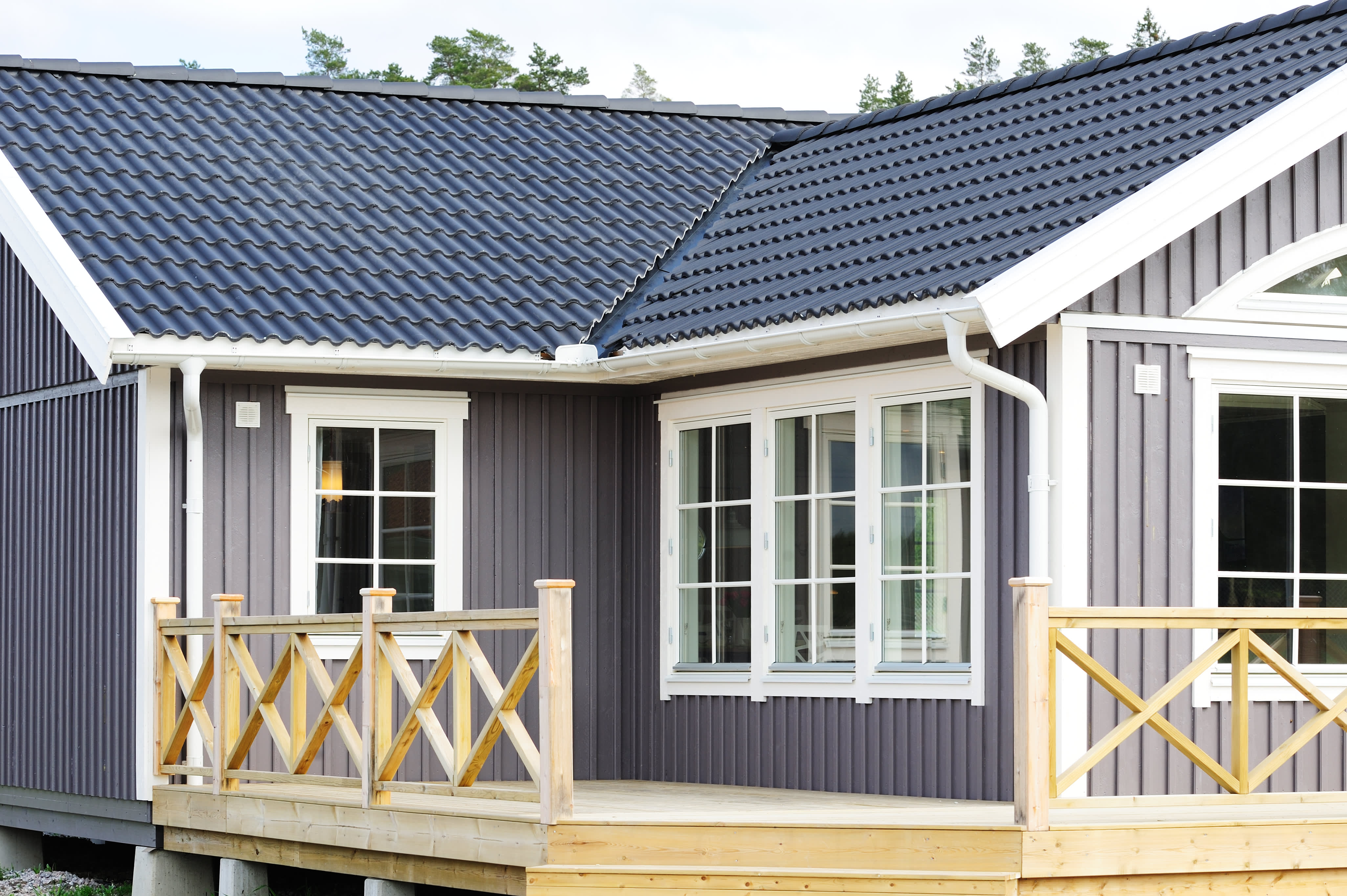 Landhaus mit Sprossenfenstern und Holzterrasse