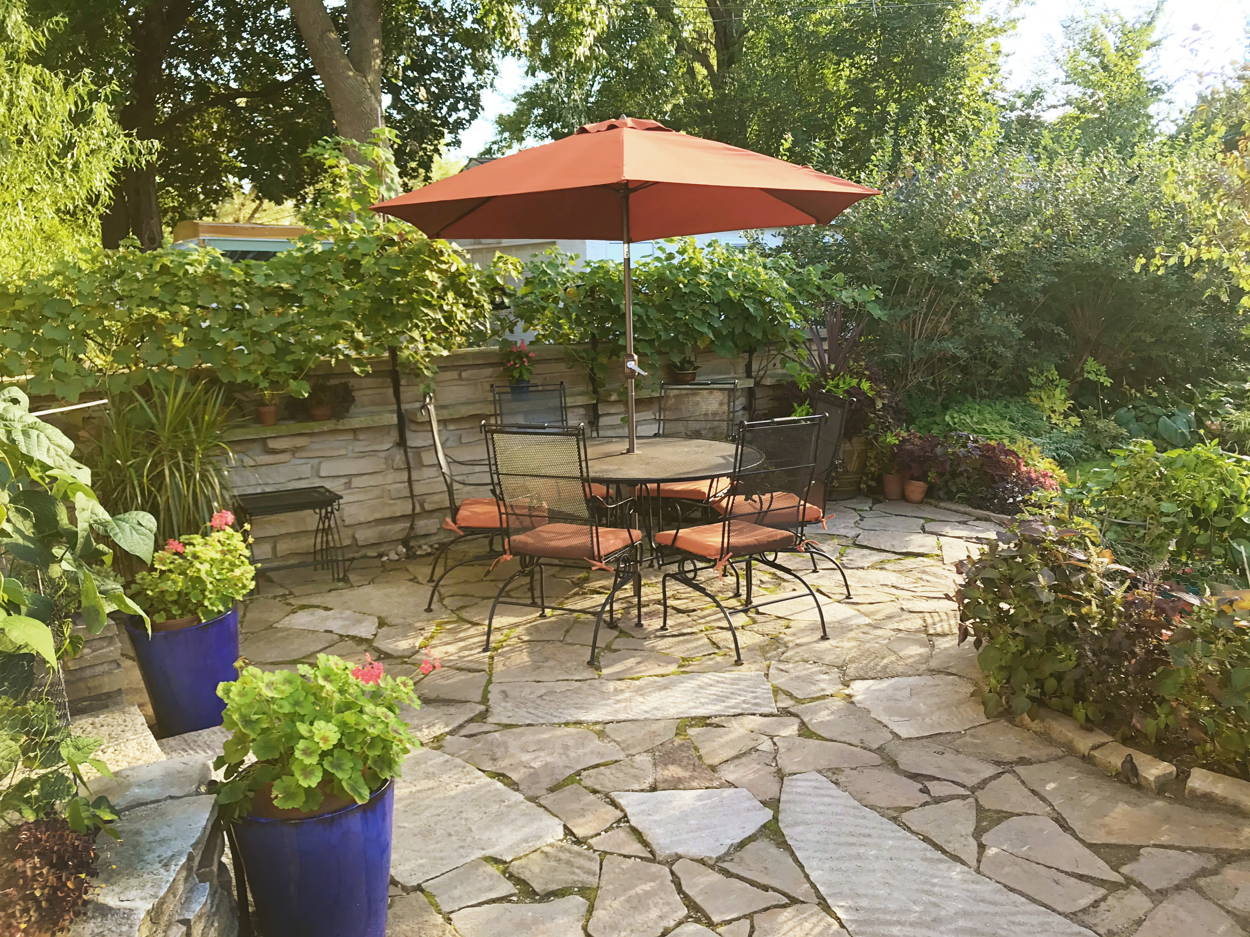 Terrasse mit Natursteinboden und Essgruppe