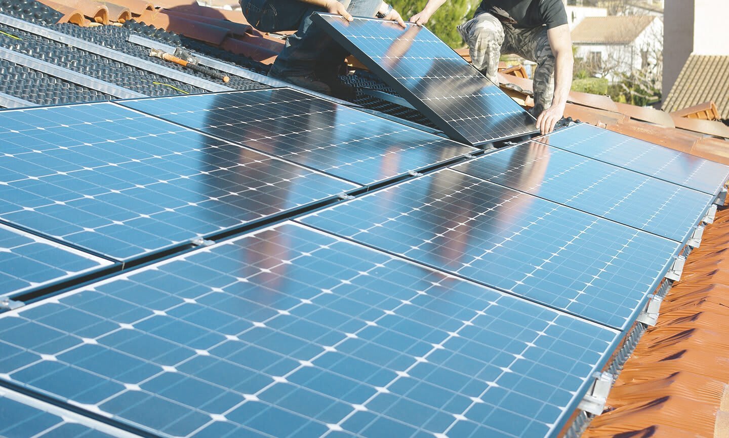 Monteure installieren Photovoltaikmodule auf einem Schrägdach