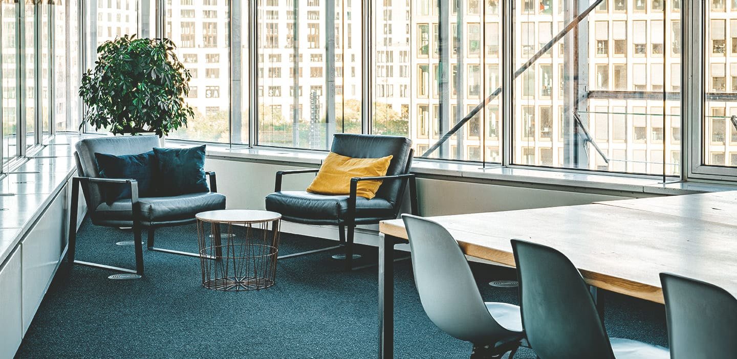 Das Bild zeigt eine Sitzecke mit zwei bequemen Sesseln im Aroundhome Büro mit Ausblick auf den Potsdamer Platz. Dieser Ort wird für unsere Experteninterviews genutzt.