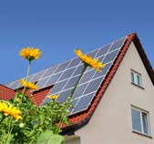 Solaranlage auf Hausdach mit Himmel und Sonnenblume