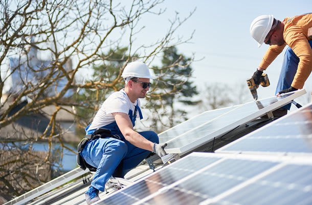Facharbeiter montieren Solaranlage auf dem Dach