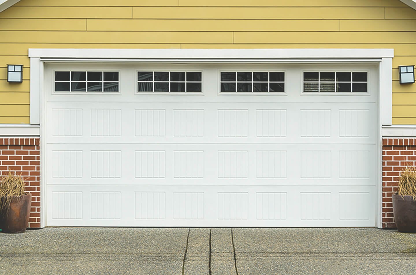 Artikelbild zum Thema Garagen Sicherheit zeigt ein breites Garagentor einer gelben Großraumgarage