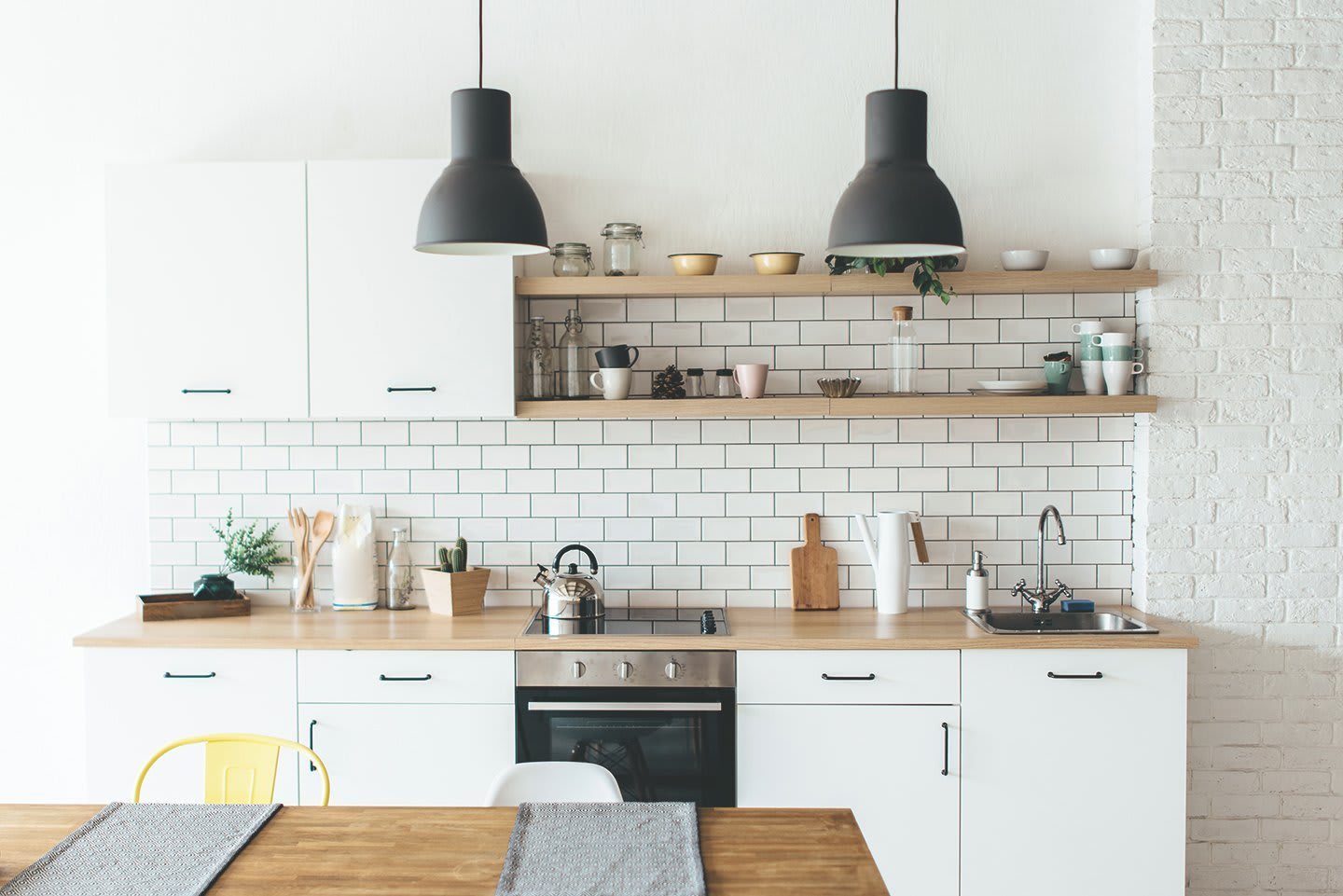 Moderne, weiße Küchenzeile mit offenem Holzregal und Esstisch