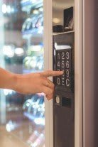 Hand drückt auf Taste an Warenautomat