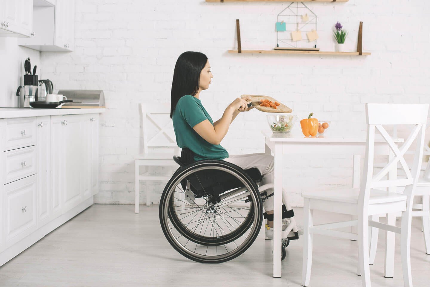 Frau im Rollstuhl an Esstisch