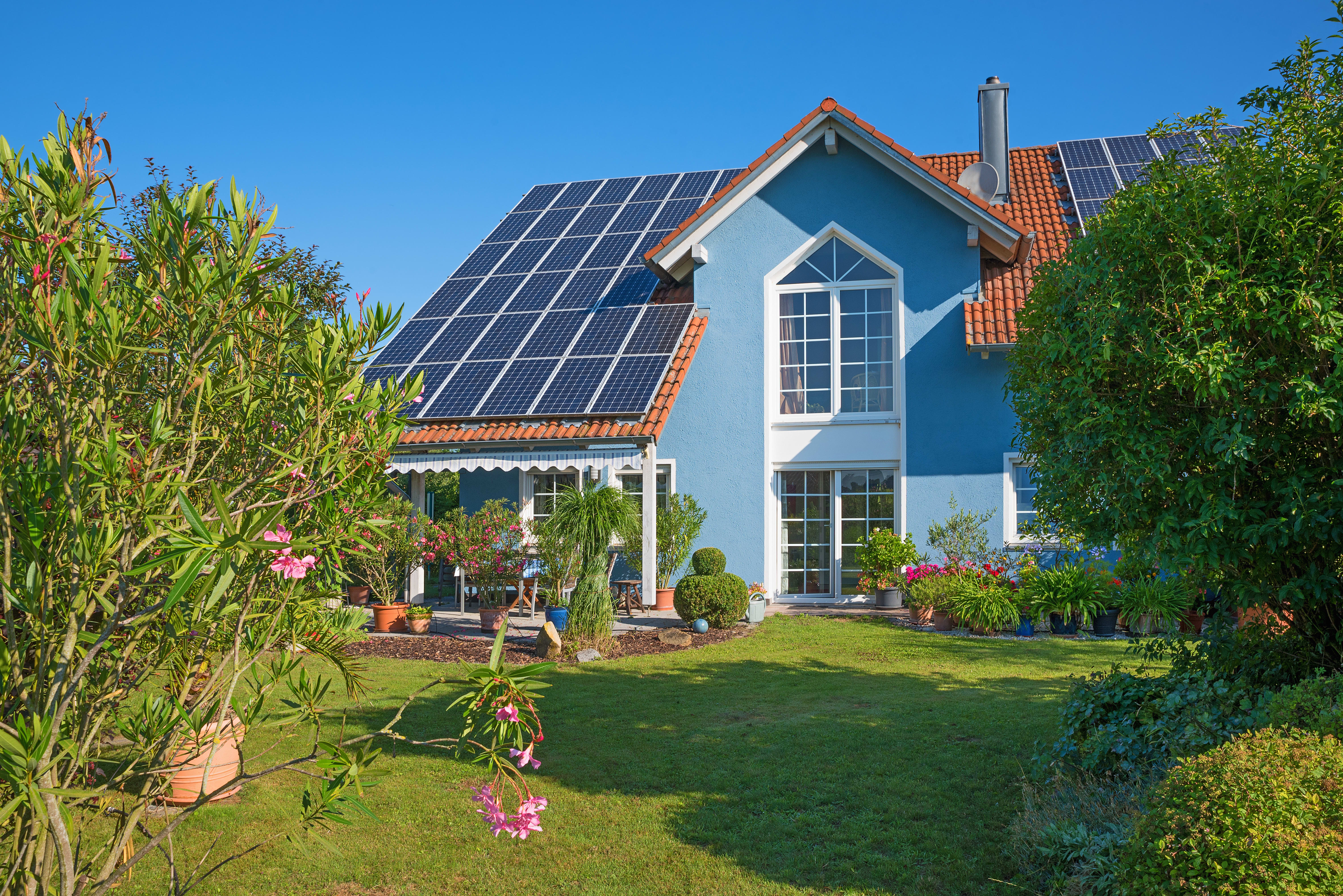 Einfamilienhaus mit Solaranlage auf dem Dach und gepflegtem Garten